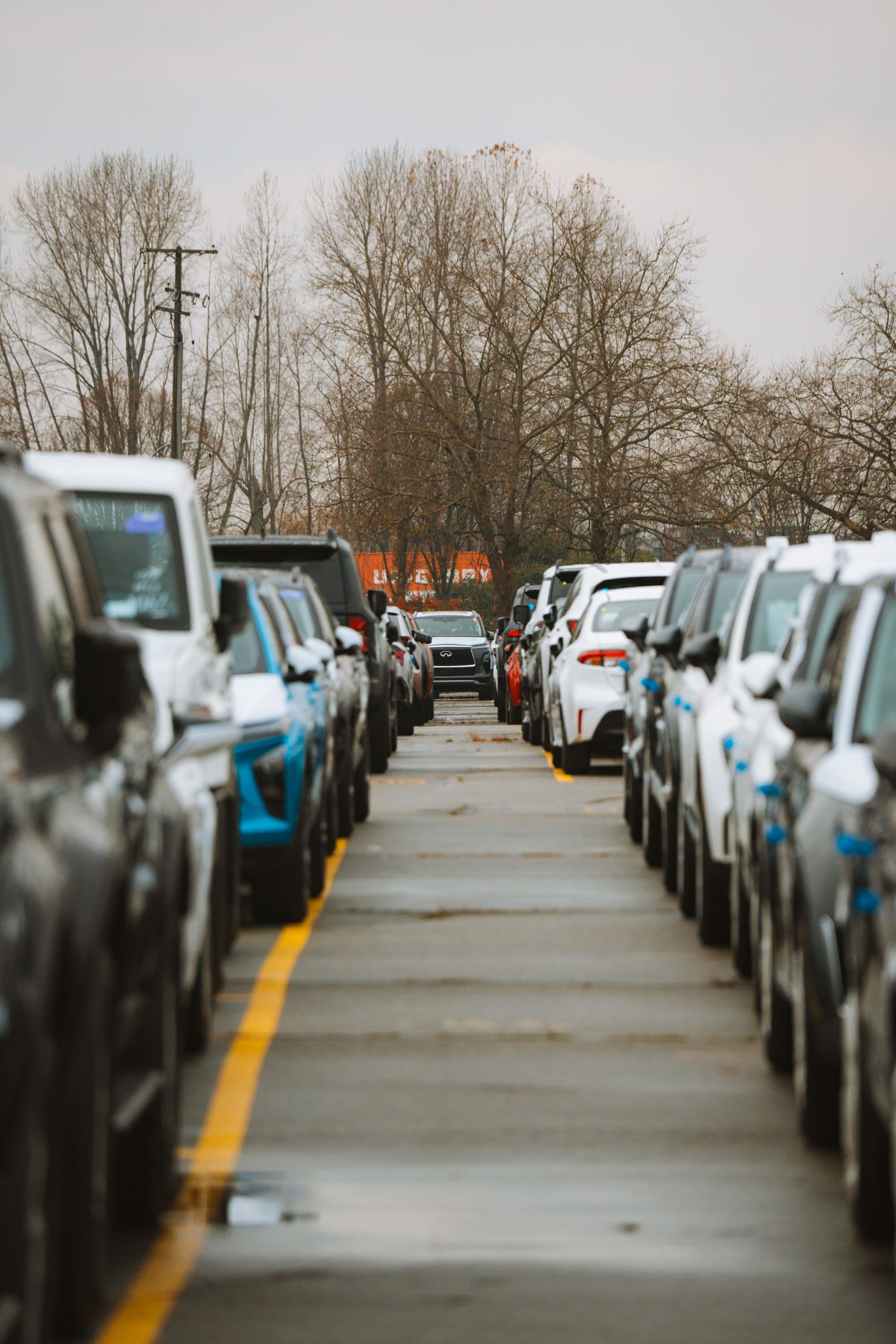 Voitures garées en file sur un parking, par temps couvert