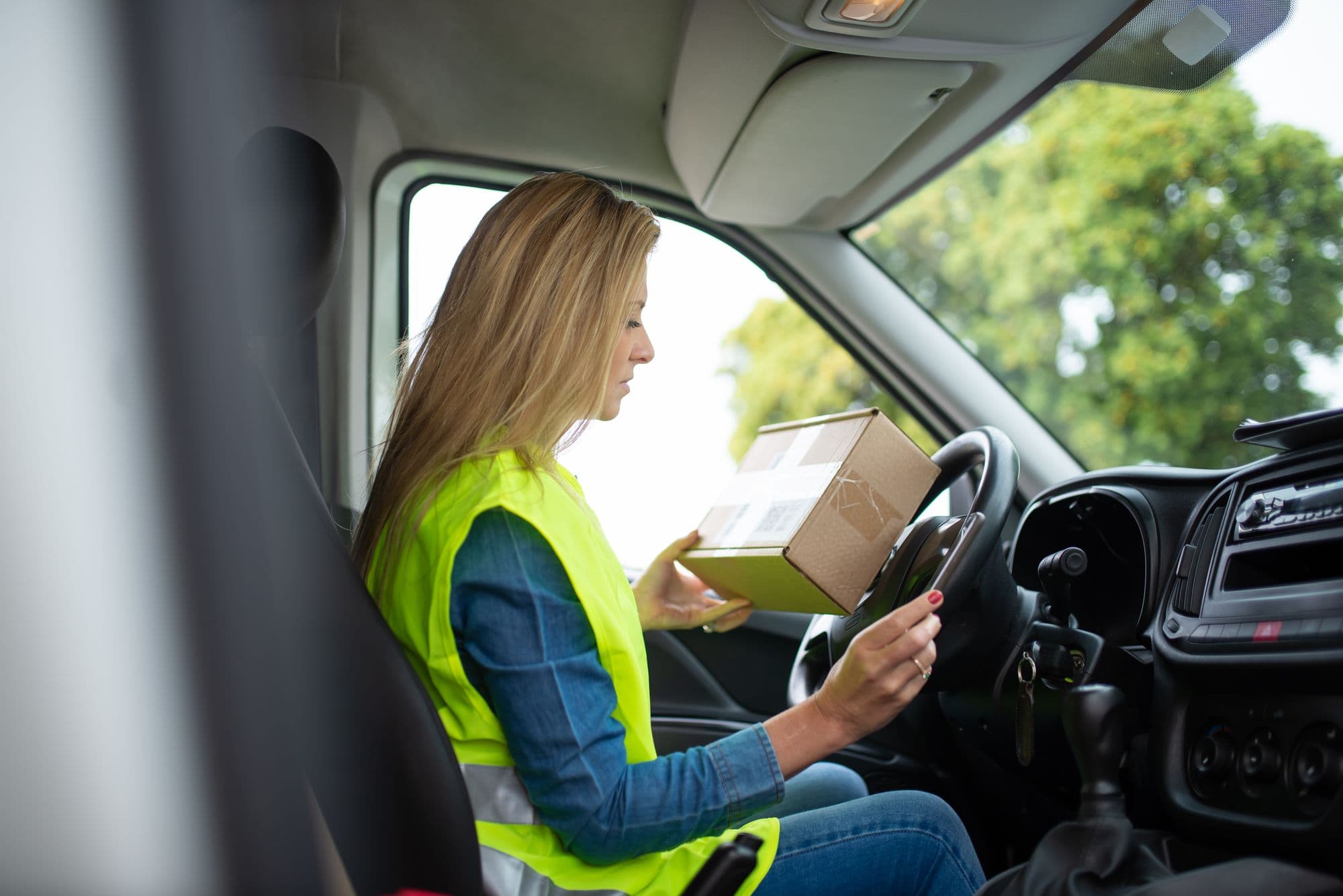 Une conductrice en gilet de sécurité dans sa camionnette
